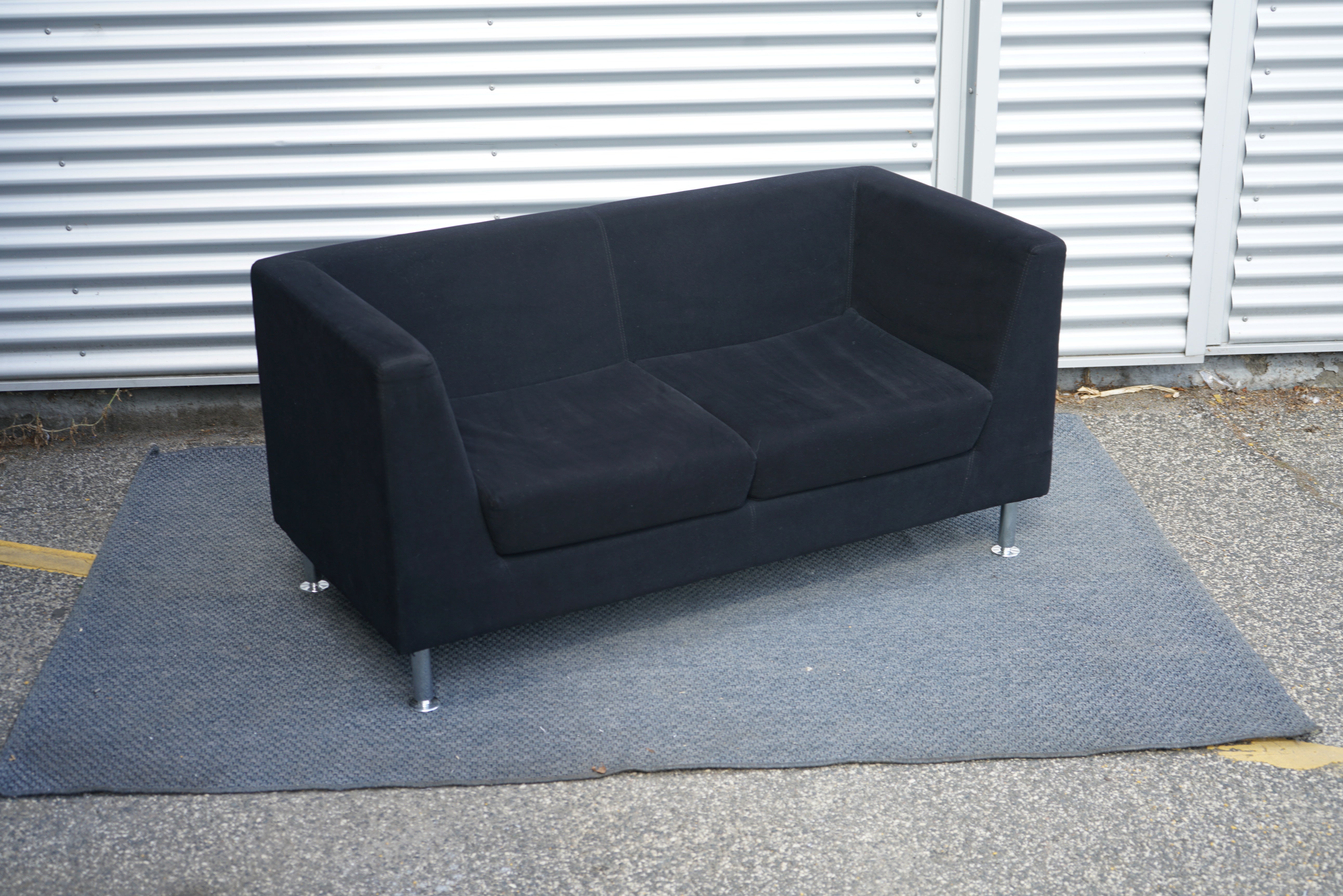 Antares 2-personers sofa 145x65 cm i mørkeblå stof set fra skrå vinkel med forkromede ben